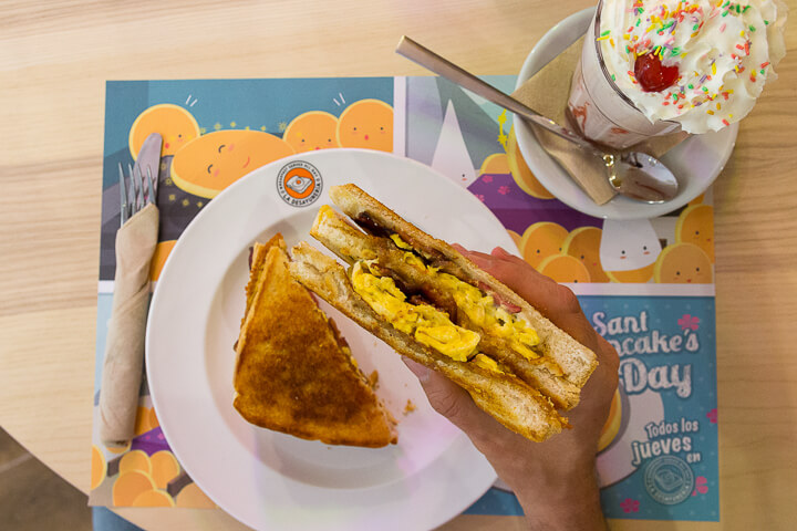 LA DESAYUNERIA MADRID Grilled Sandwich Sant Antoni con huevo revuelto, crispy bacon, cheddar y salsa ranchera